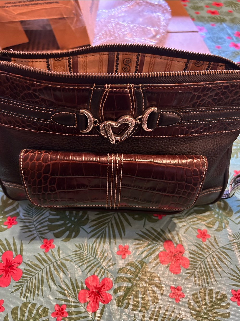 Brighton crossbody with pocket on front and back.  Silver heart hardware